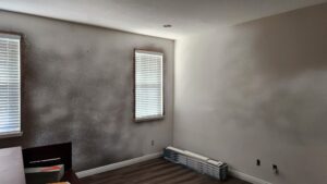 Restored room after water damage and mold remediation, walls ready for painting